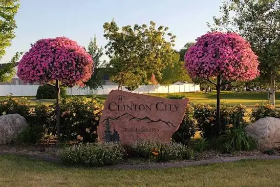 Clinton City, Utah welcome sign surrounded by hanging flower baskets and landscaping