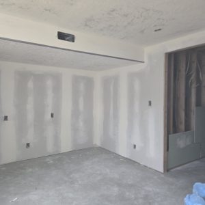 Interior construction in Clinton, UT, showing freshly mudded drywall seams and textured ceilings.